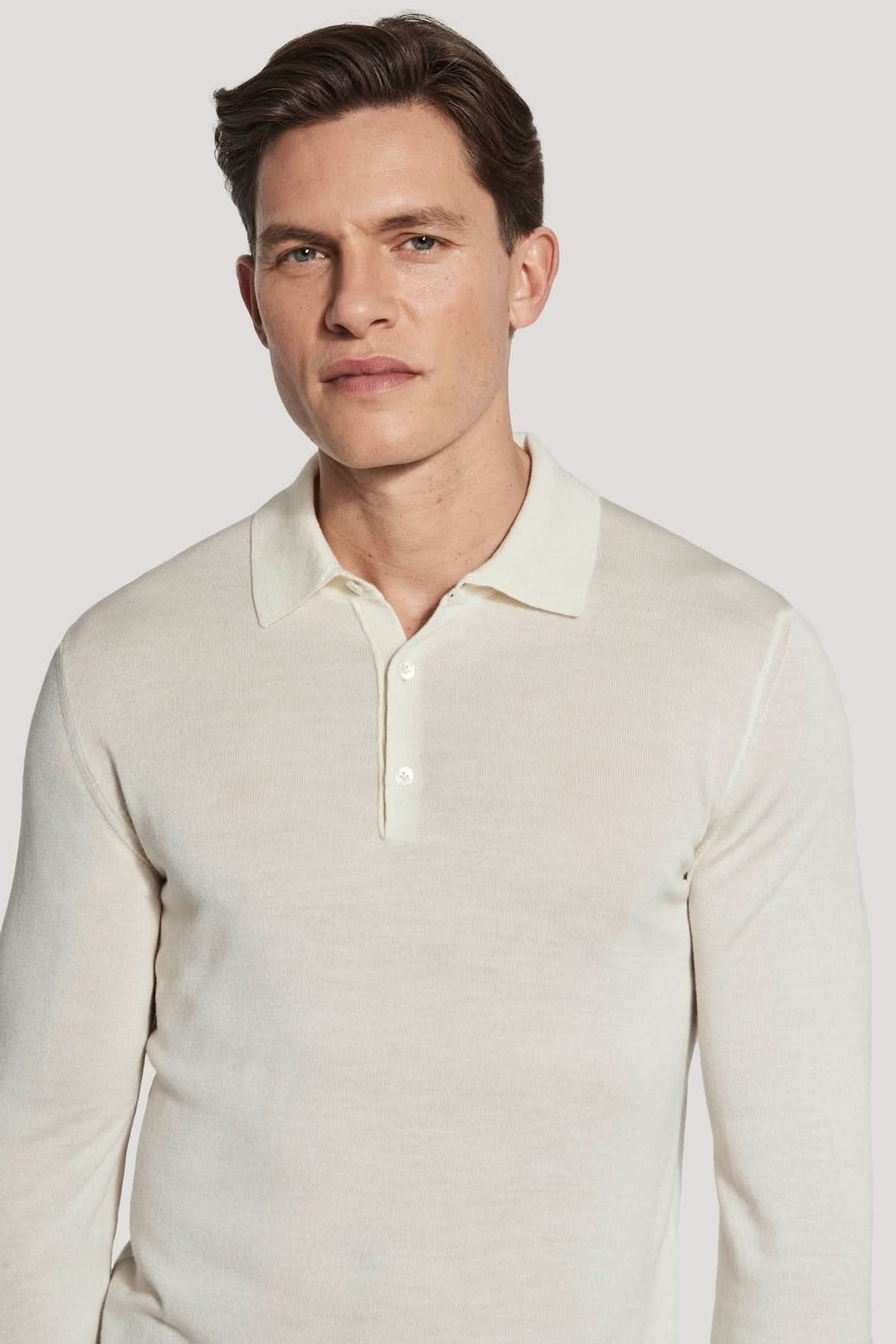 Homme portant un polo manches longues en laine mérinos et soie, élégant et moderne, parfait pour un style sophistiqué.