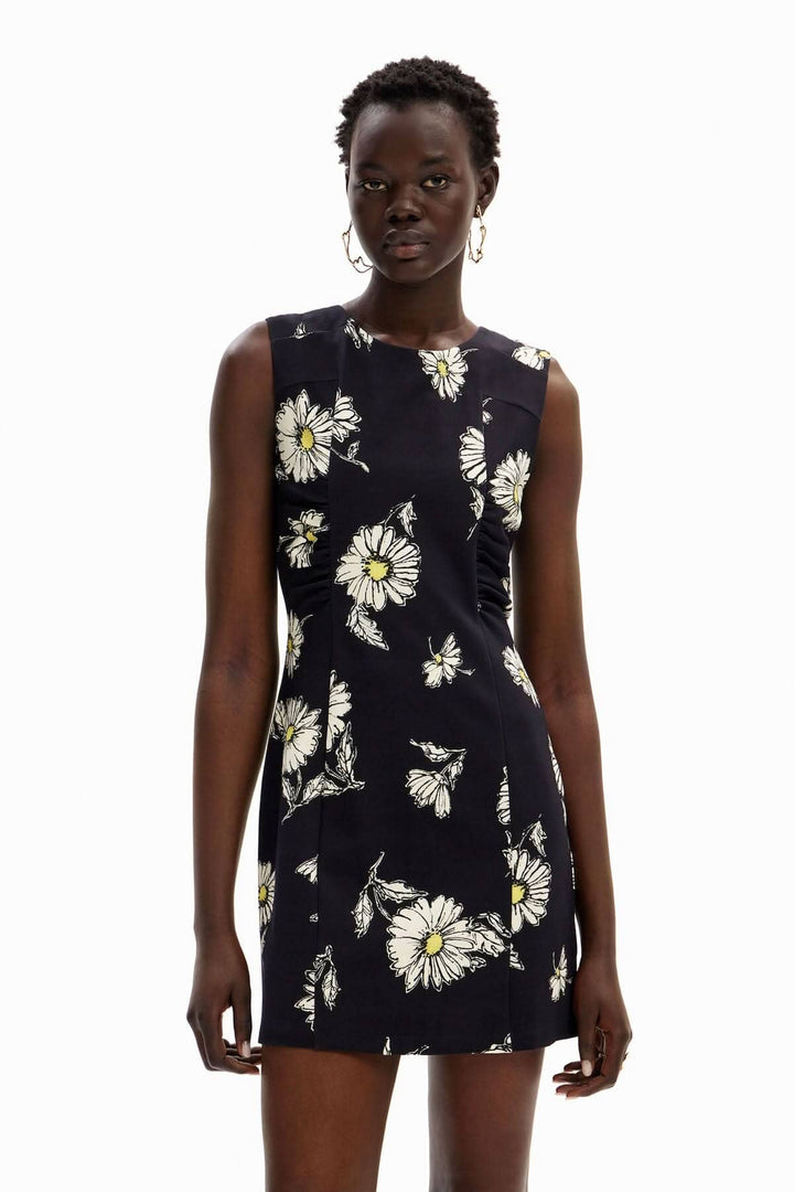 Robe courte sans manches à imprimé de marguerites blanches sur fond noir, idéale pour les journées chaudes.