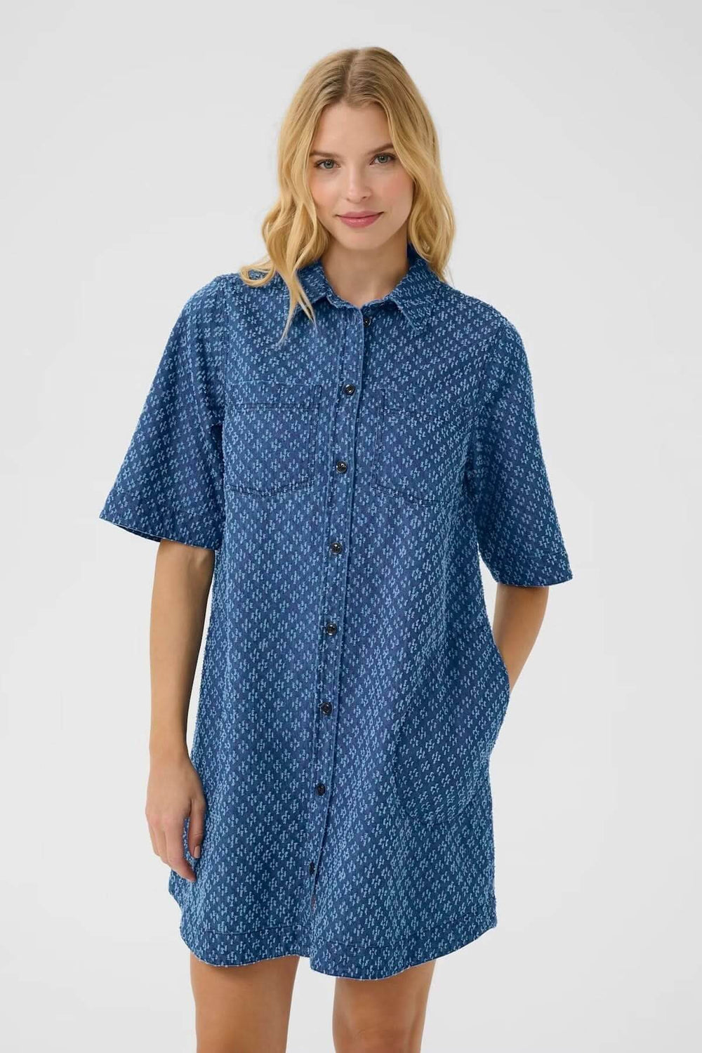 Robe-chemise en denim léger avec motifs géométriques discrets, coupe ample et manches courtes, parfaite pour l'été.