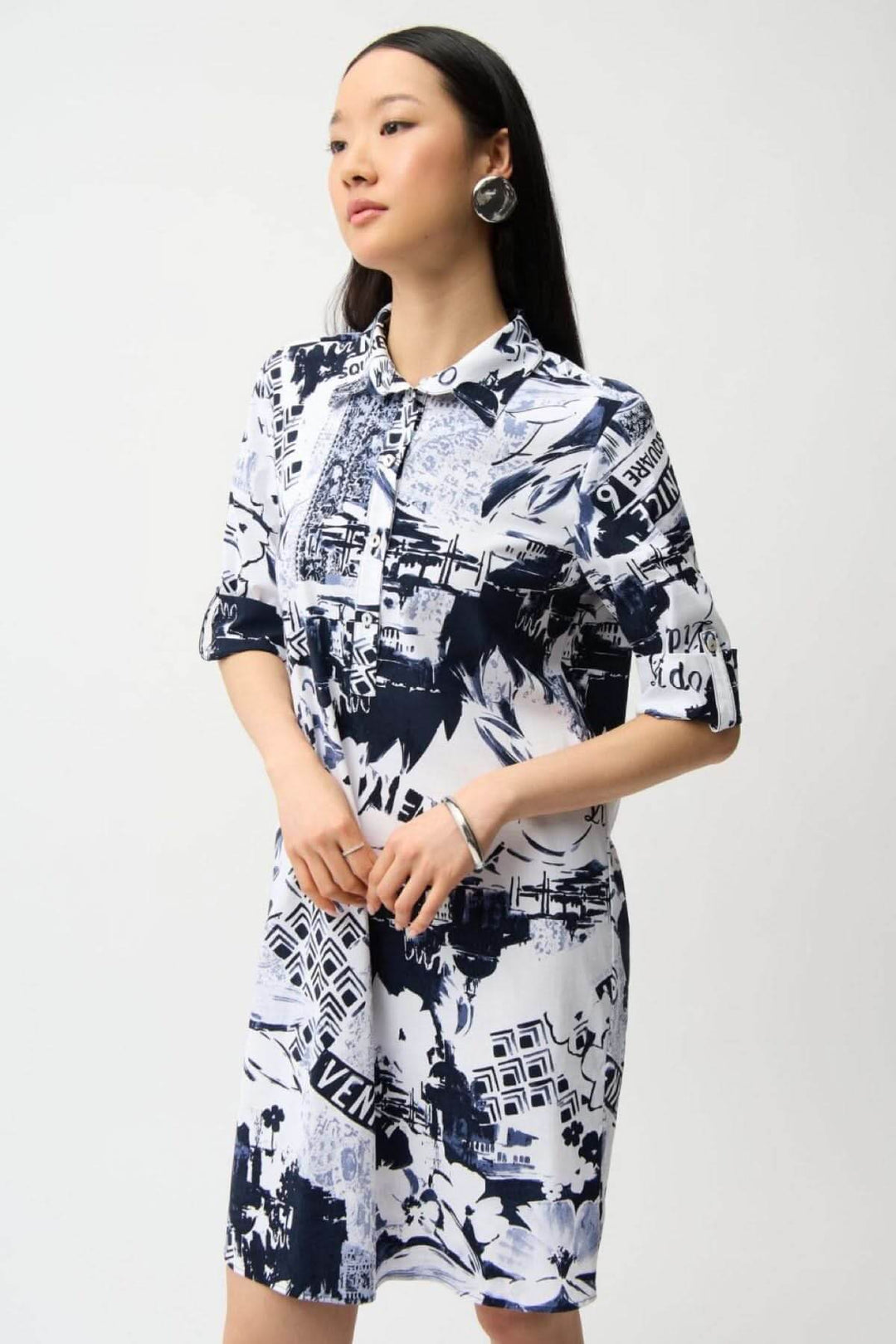 Femme portant une robe chemise imprimée avec motif graphique urbain, coupe droite et col chemise, style polyvalent et confortable.