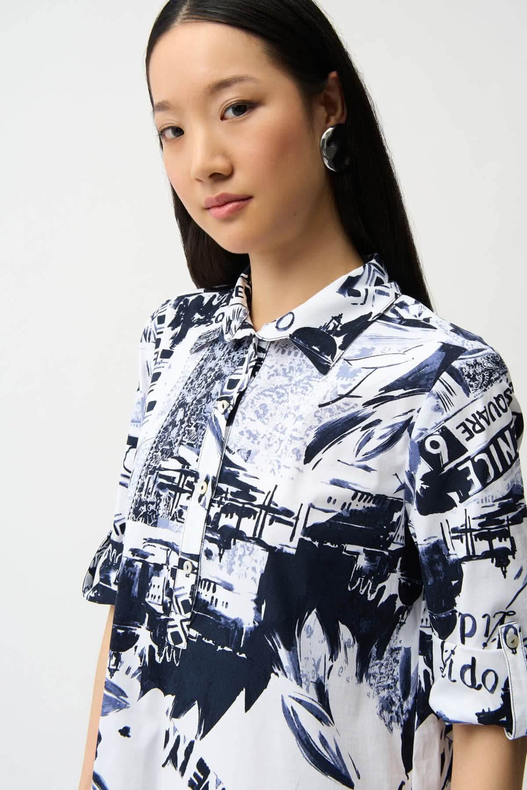 Femme portant une robe chemise imprimée avec un motif graphique urbain et col chemise structuré.