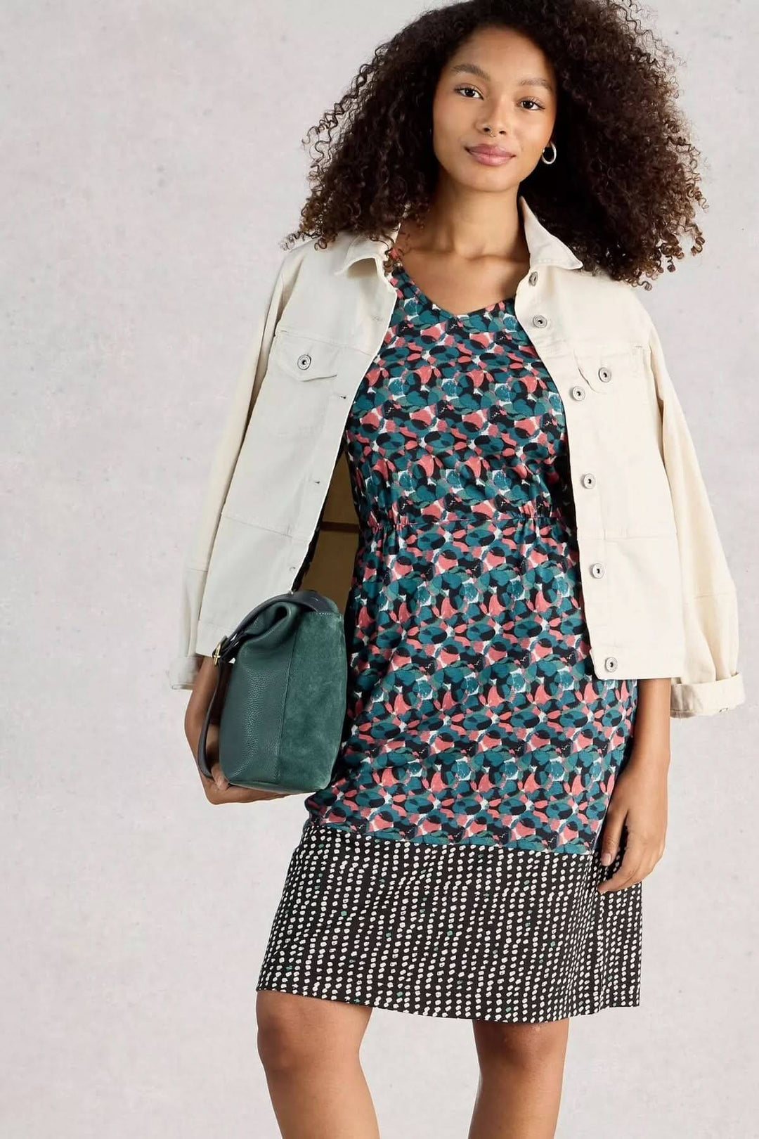 Femme portant Robe à col V Tallie avec imprimé graphique, veste blanche et sac vert, idéale pour le quotidien et le bureau.