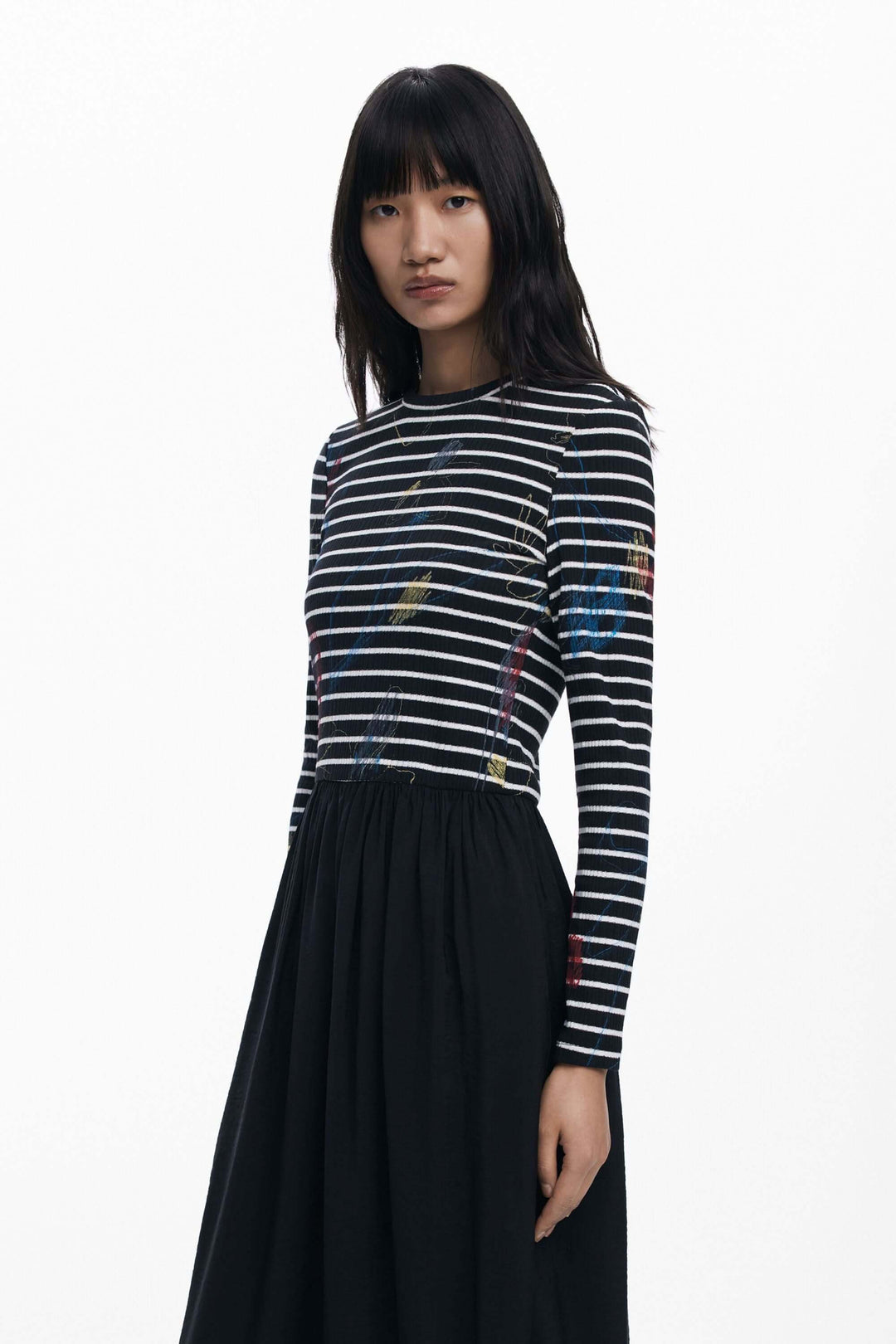Robe combinée à rayures avec haut graphique à manches longues et jupe fluide noire, parfaite pour un style moderne et élégant.