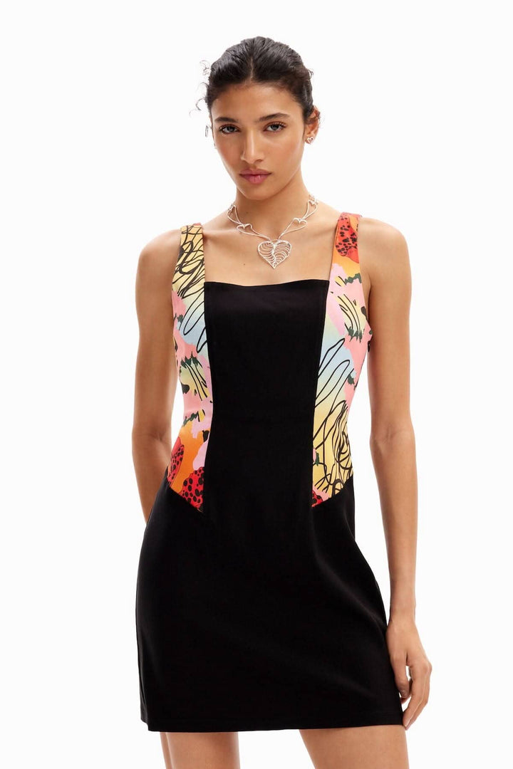 Robe courte noire avec impression florale sur les bretelles, décolleté carré et coupe ajustée, parfaite pour une soirée.