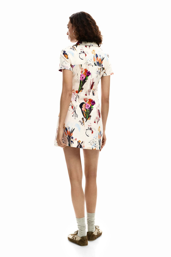 Femme portant une robe courte collage aux motifs artistiques, de dos, montrant la coupe ajustée et la silhouette structurée.