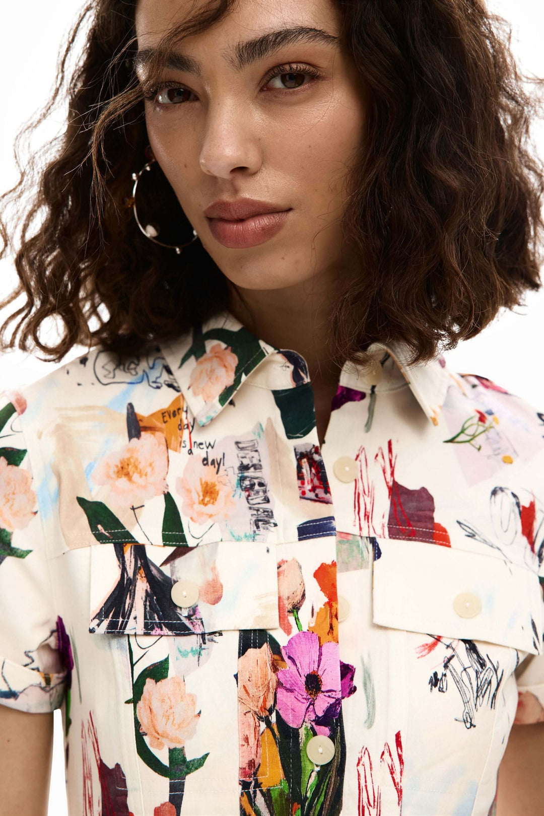 Femme portant une robe courte collage avec imprimé artistique, col chemise et manches courtes.