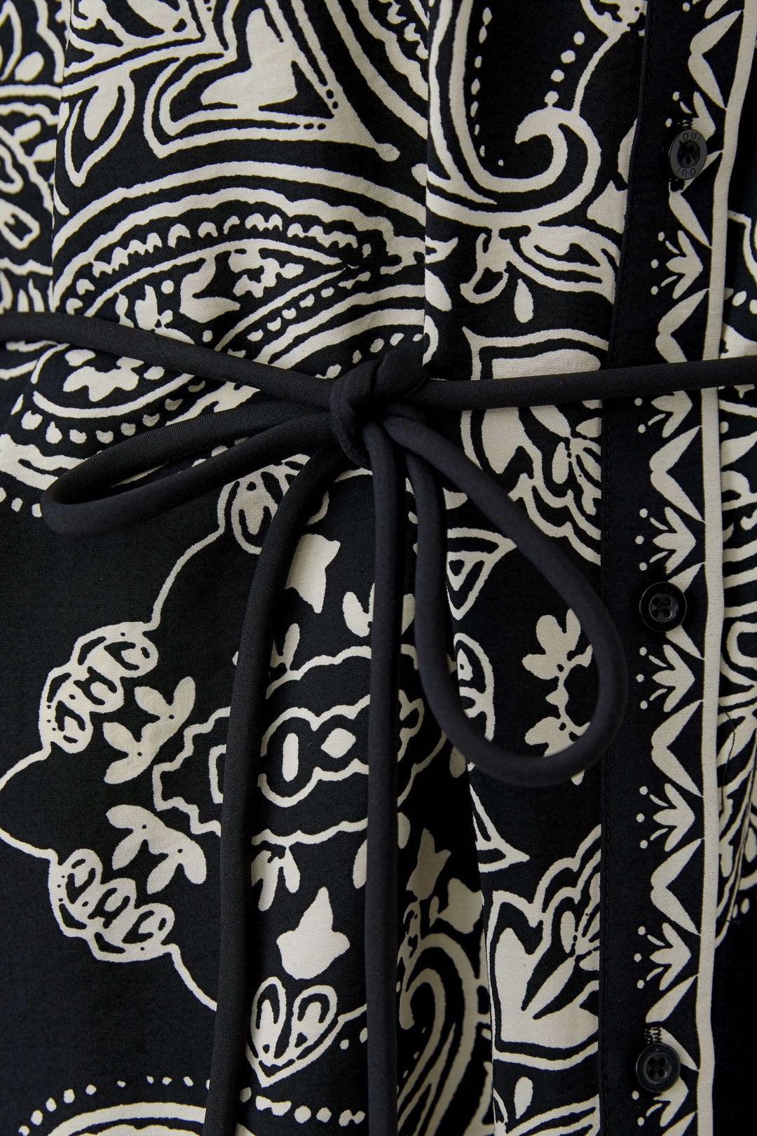 Robe courte imprimé graphique avec ceinture à nouer pour un ajustement élégant, inspirée du style bohème.