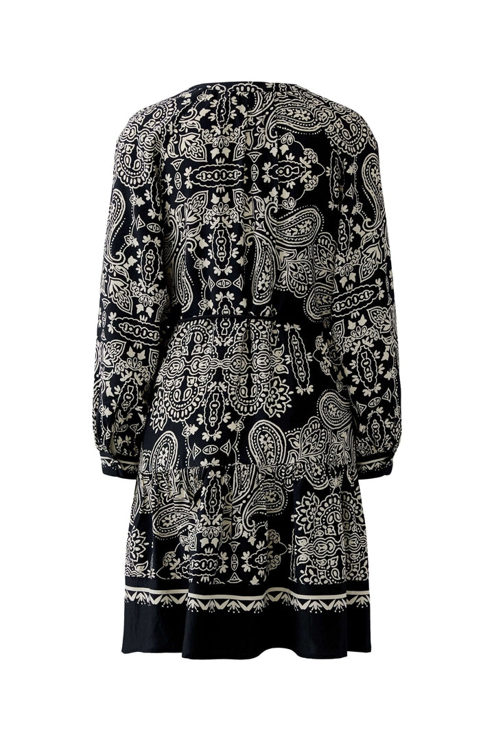 Robe courte imprimé graphique avec motifs bohèmes noirs et blancs, vue arrière, coupe structurée et ceinture à nouer élégante.
