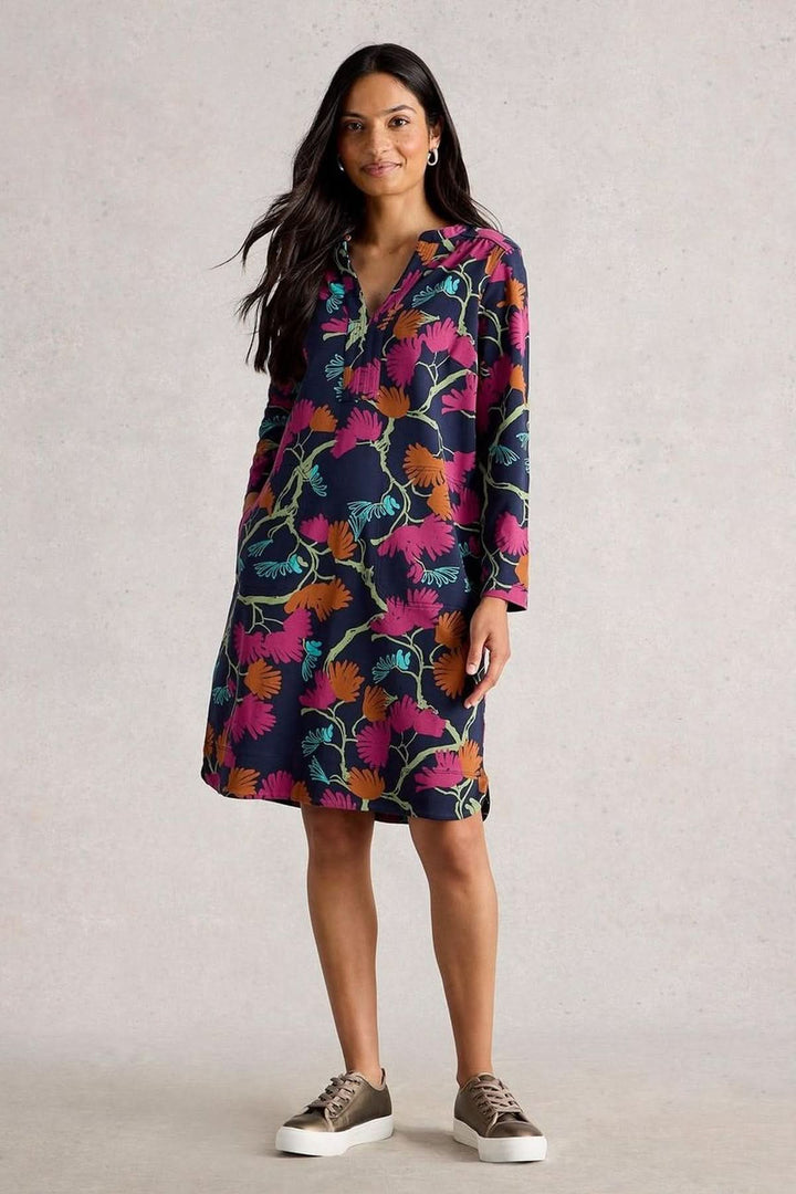 Robe droite imprimée col tunisien avec manches 3/4 en jersey botanique, portée par une femme avec des baskets, look décontracté chic.
