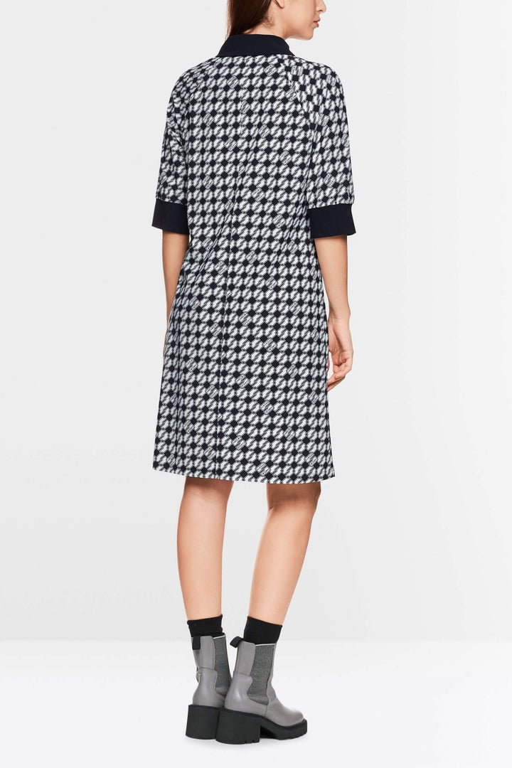 Robe en jersey scuba à imprimé géométrique, dos, portée avec des bottines grises.