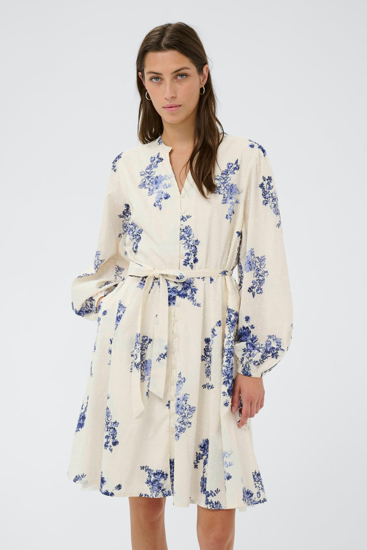 Robe fleurie Avira avec motif floral bleu, ceinture nouée, manches longues bouffantes, jupe évasée, élégante pour occasions spéciales.