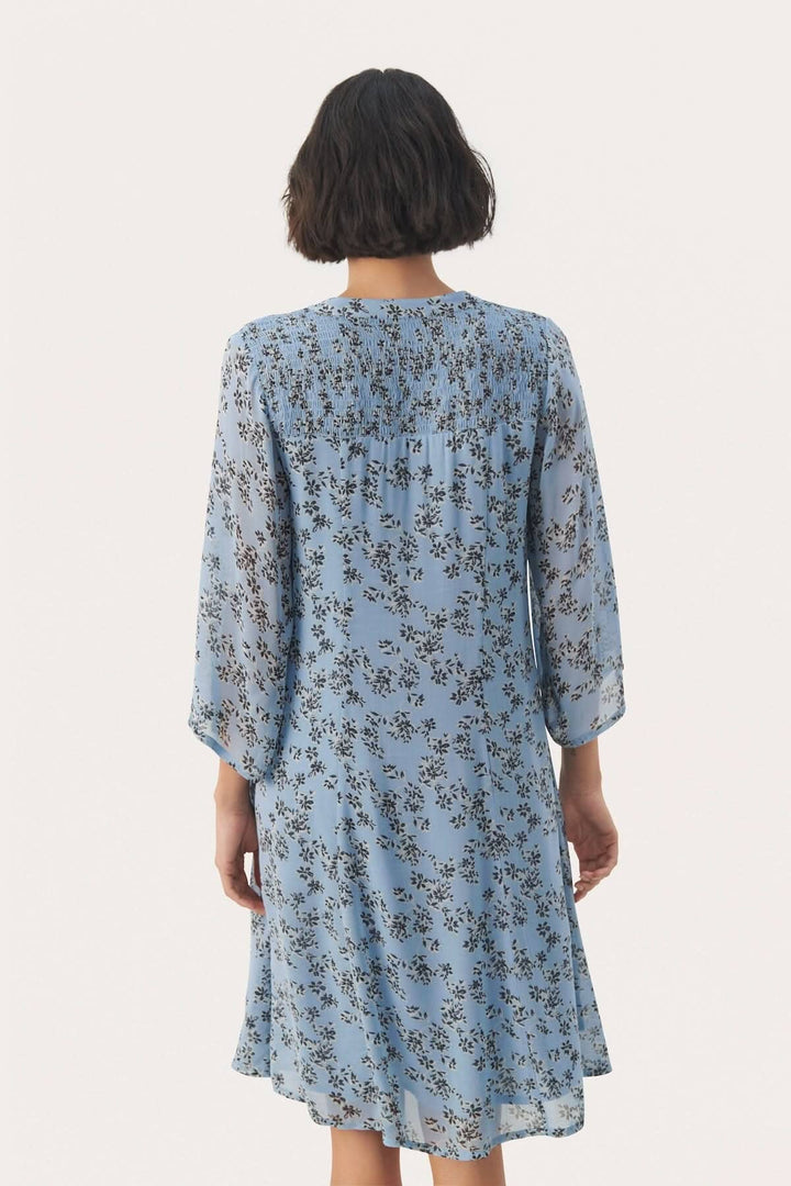 Détails arrière de la robe fleurie Elka, silhouette élégante en tissu léger, parfaite pour toutes les occasions.