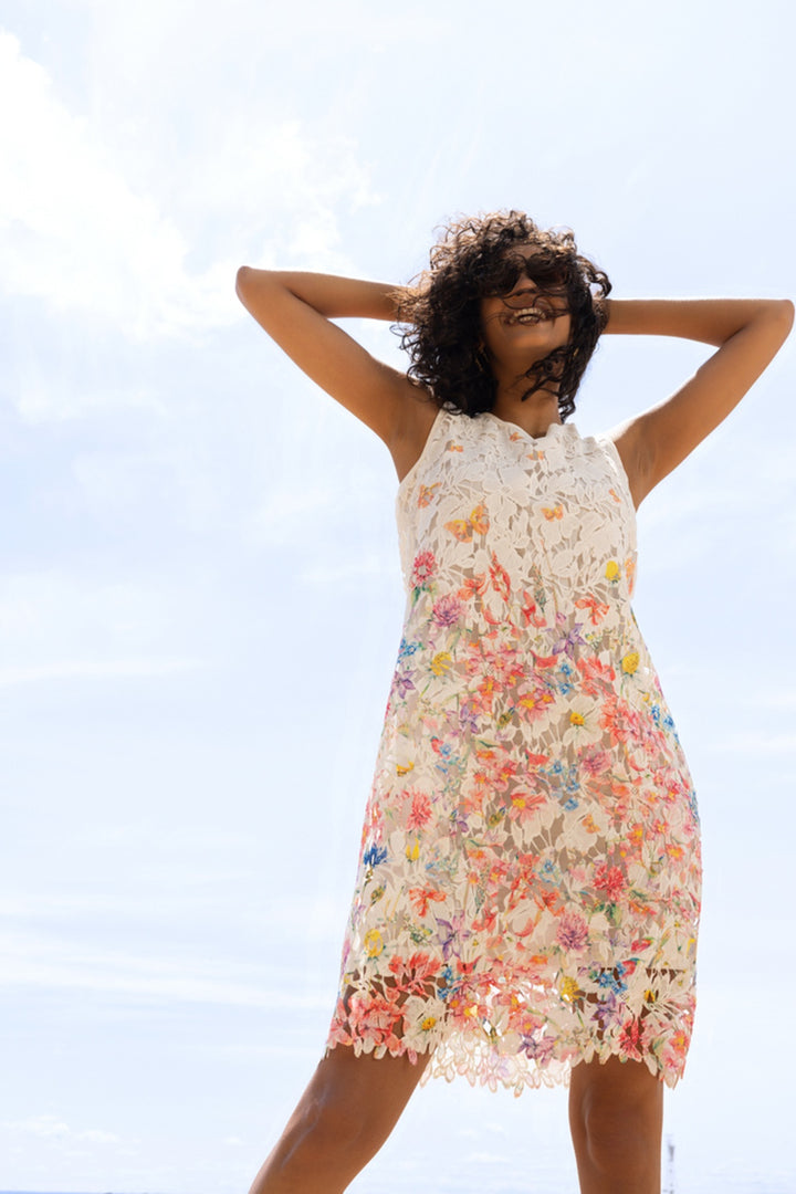 Femme portant une robe florale avec détails, en dentelle élégante, parfaite pour les occasions spéciales et estivales.