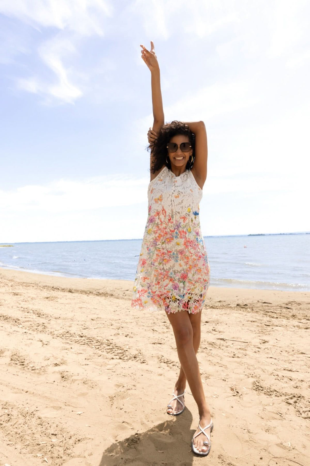 Femme portant une robe florale avec détails sur la plage, robe en dentelle, été