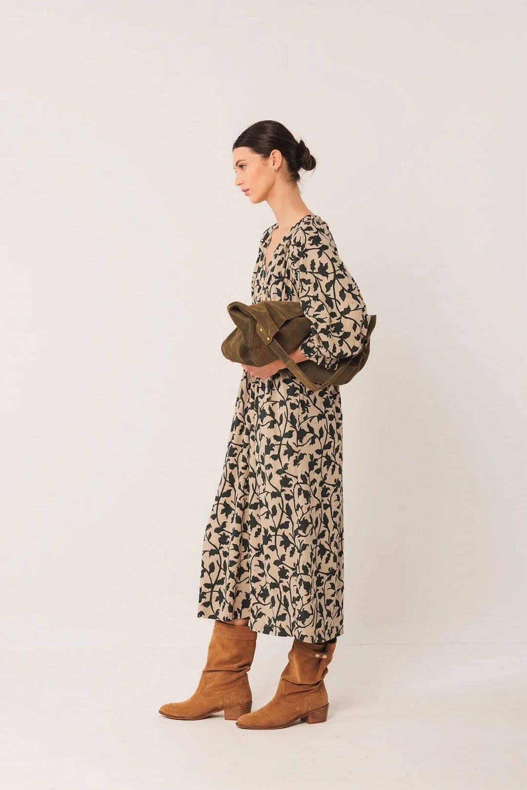 Robe longue fluide avec imprimé botanique, silhouette féminine, look bohème avec bottes en cuir, décolleté en V, coupe aérienne élégante.