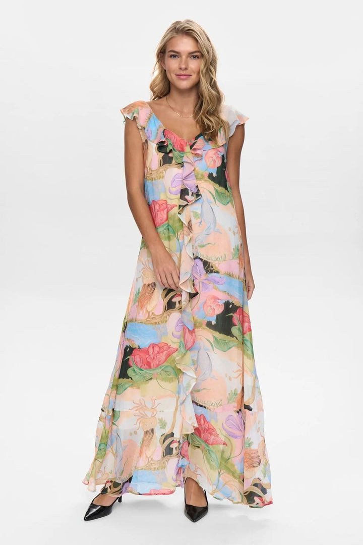 Femme portant une robe longue à volants avec un motif floral, parfaite pour les occasions spéciales et les sorties estivales.