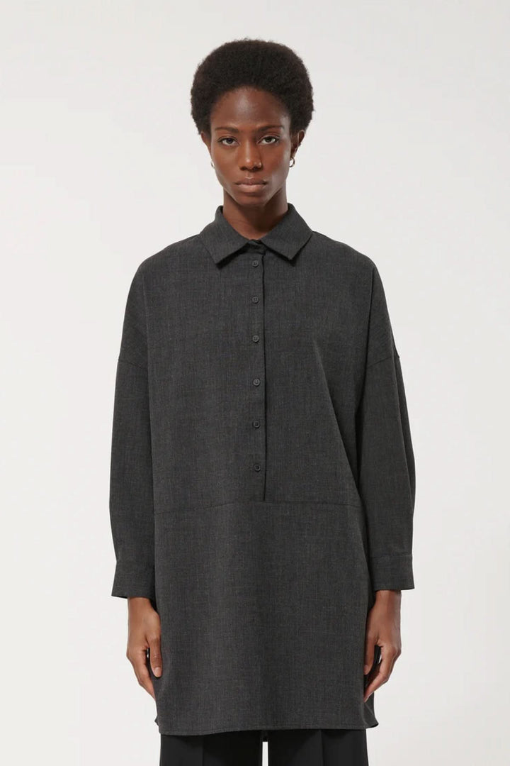 Robe à manches longues noire avec coupe ample et col classique, style minimaliste pour une élégance polyvalente.