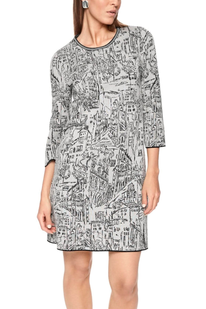 Robe à motif urbain avec imprimé graphique en noir et blanc, encolure ronde, manches 3/4 et coupe ample et fluide.