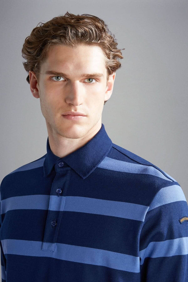 Homme portant un polo rayé bleu marine et bleu clair, alliant élégance et confort.