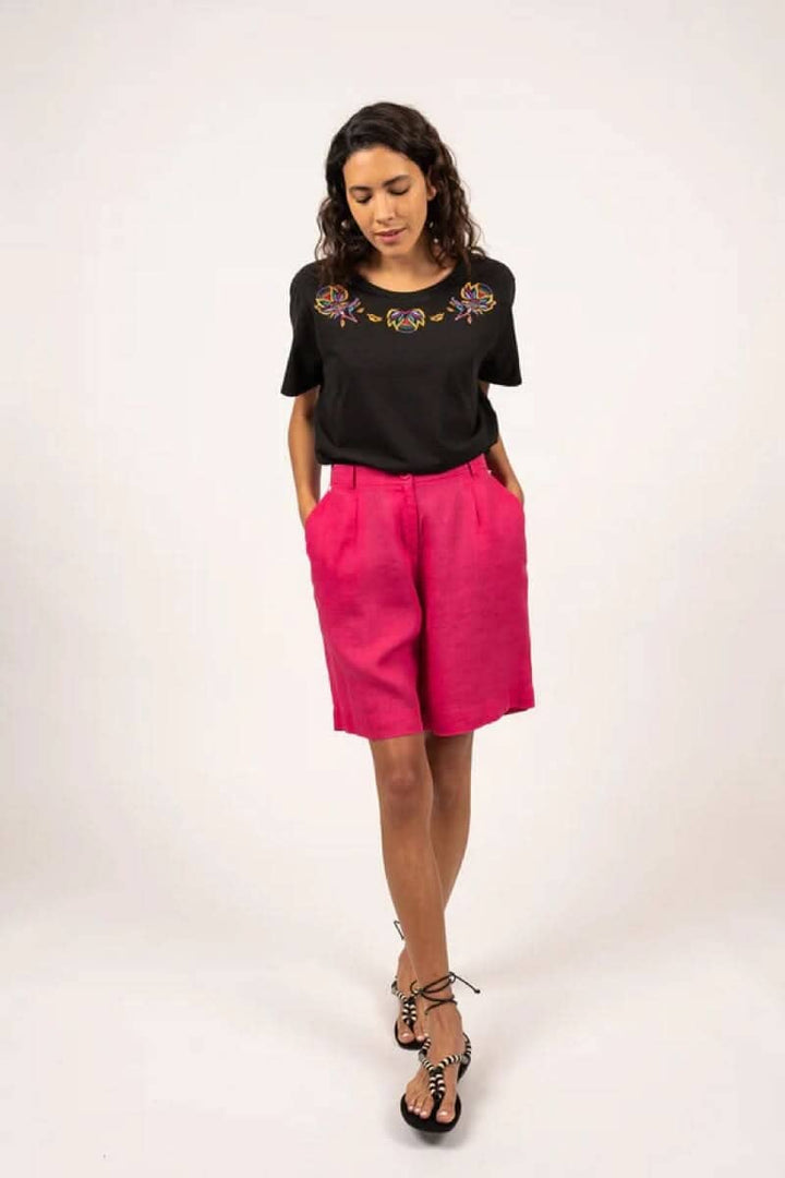 Femme portant un short Cécile rose et un haut noir, look chic et contemporain, idéal pour l&