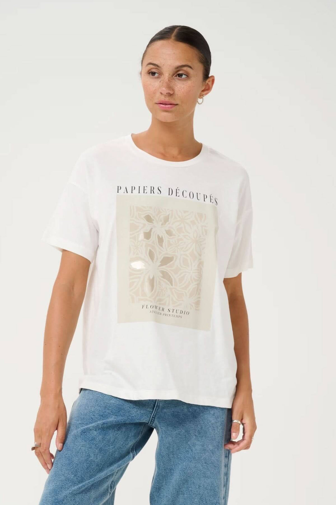 T-shirt blanc avec imprimé artistique inspiré du papier découpé, coupe décontractée et encolure ronde.