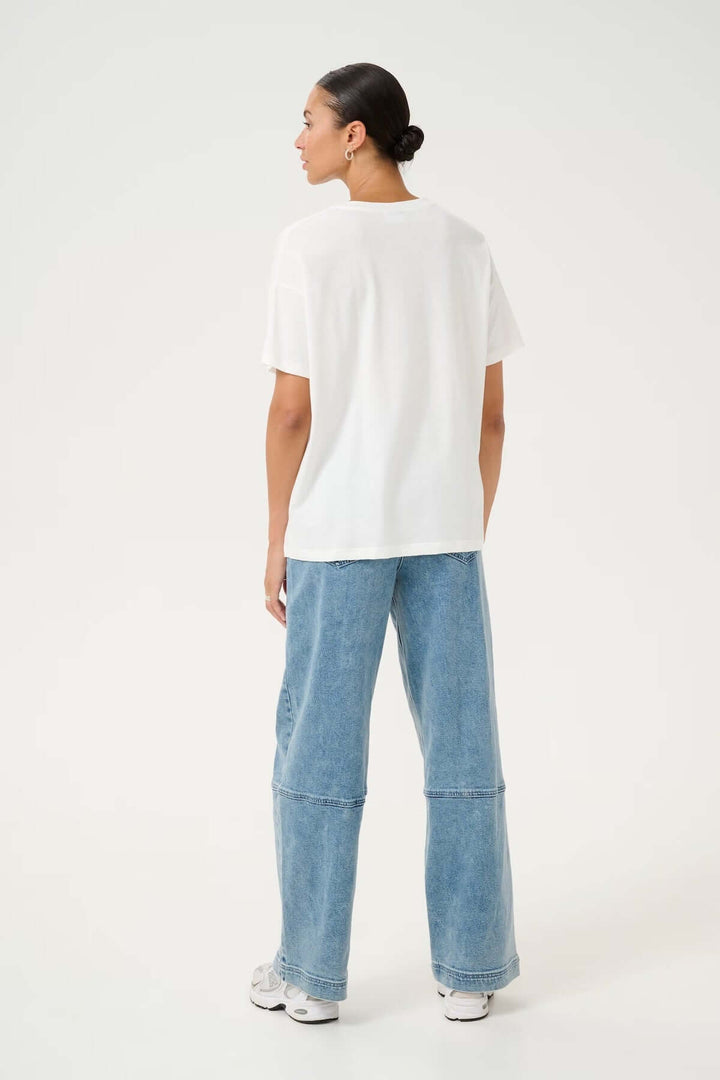 Modèle portant un T-shirt blanc classique avec un jean ample, vue arrière, style décontracté.