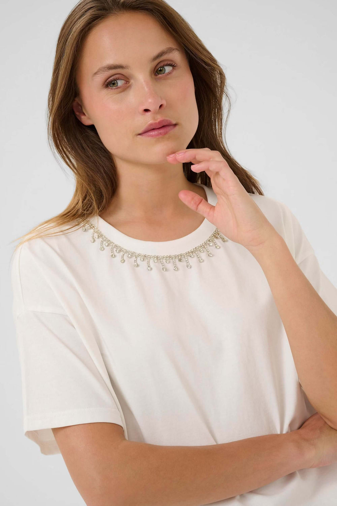 Femme portant le T-shirt Helen avec manches courtes et col rond, idéal pour un look minimaliste ou superposé avec un cardigan ou blazer.