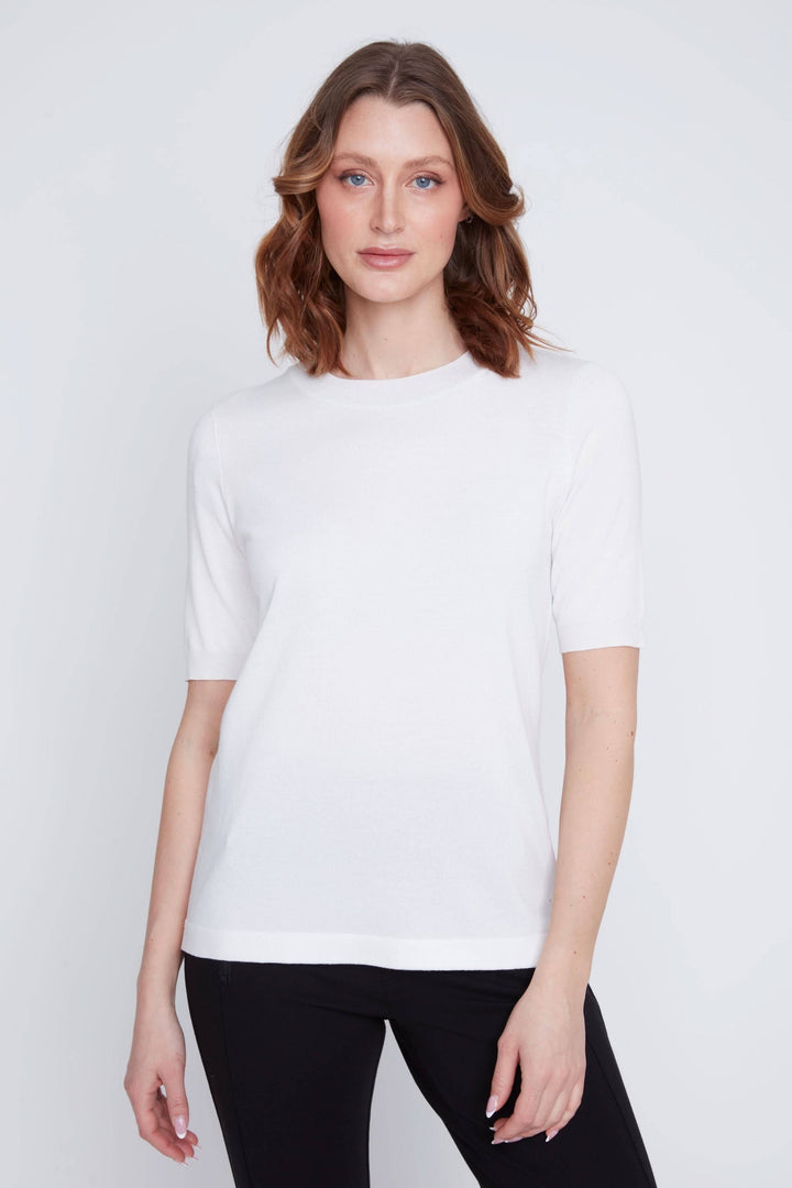 Femme portant un T-shirt classique blanc à manches courtes, coupe droite confortable pour un look minimaliste et élégant.