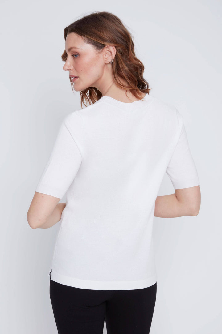 Femme portant un T-shirt classique blanc à manches courtes, coupe droite et encolure ronde, idéal pour un look minimaliste et élégant.