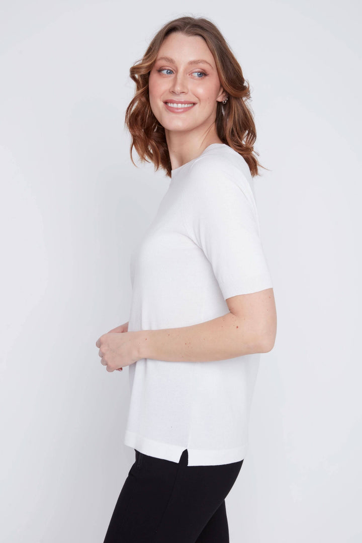 Femme portant un t-shirt classique blanc à manches courtes et coupe droite, idéal pour un look minimaliste et élégant.