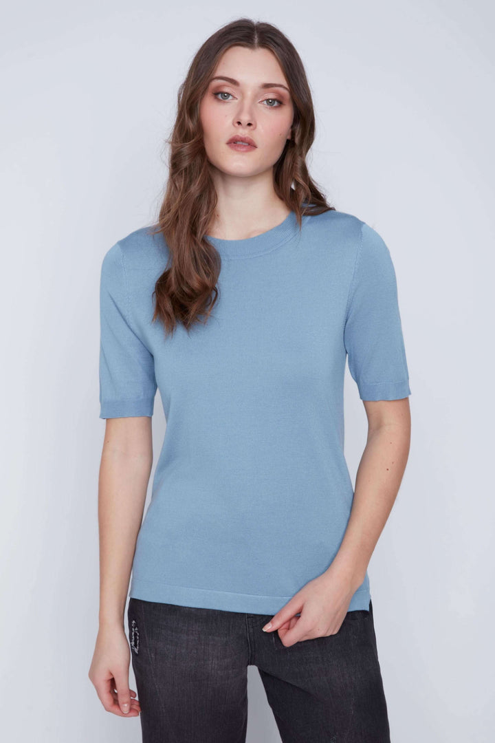 Femme portant un T-shirt classique à manches courtes, coupe droite, couleur bleu, idéal pour un look minimaliste et élégant.