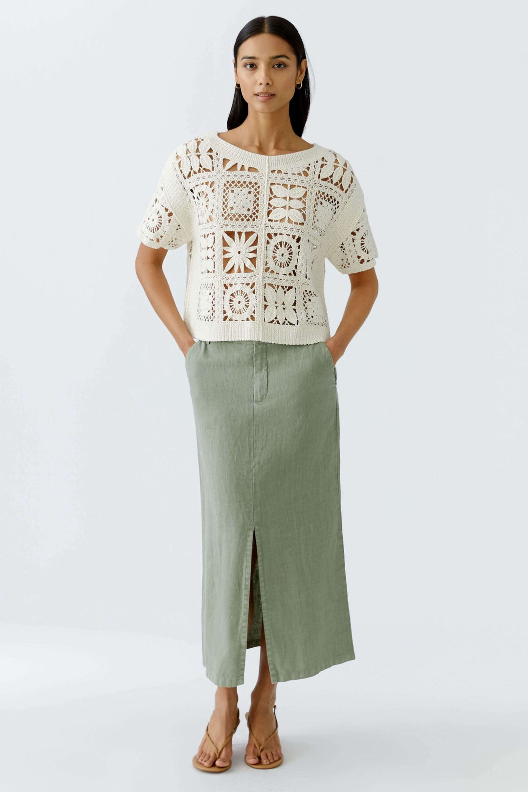 T-shirt crocheté à motifs géométriques porté avec une jupe longue, style bohème chic, pour un look estival élégant.
