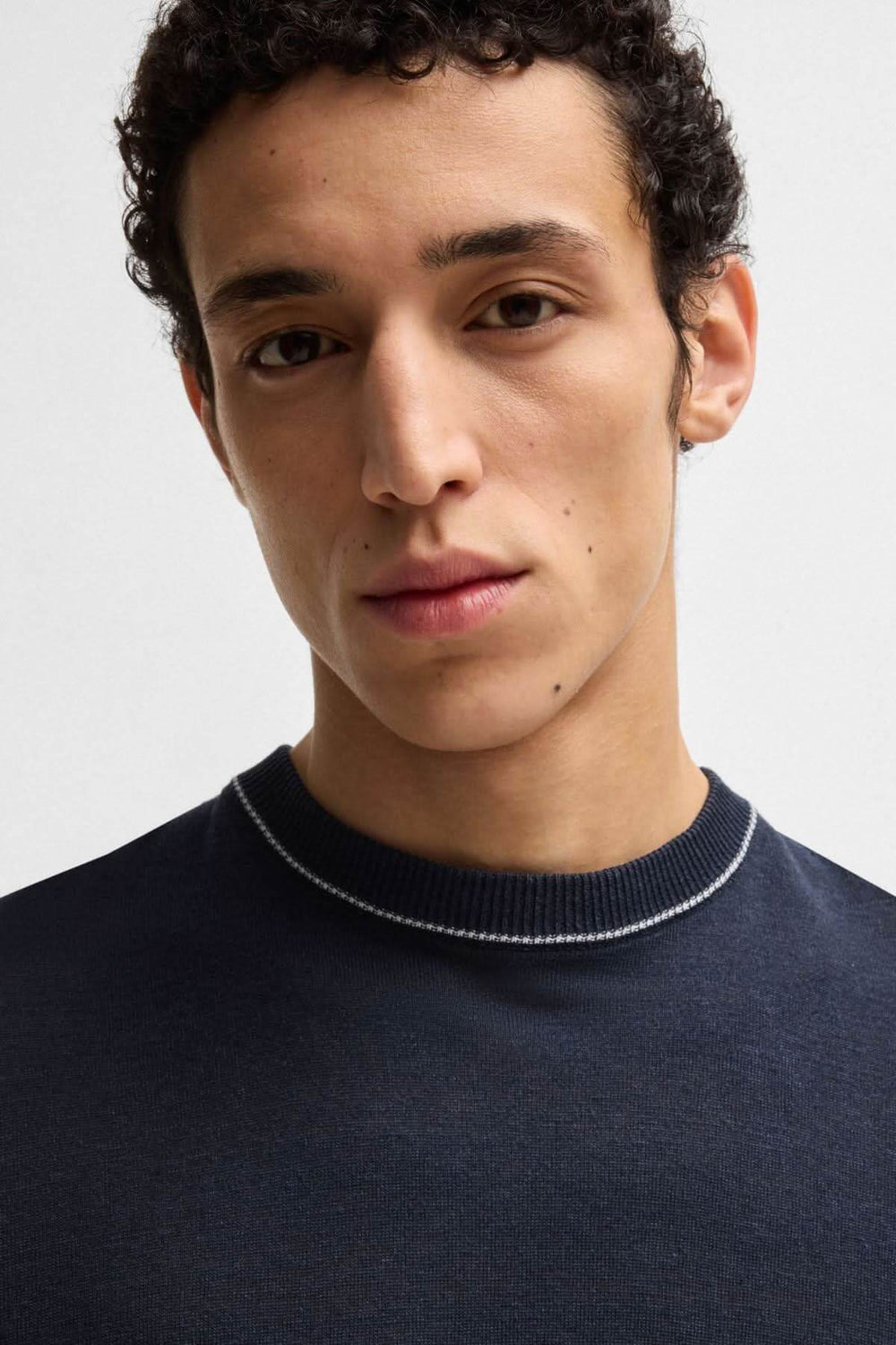 Homme portant un t-shirt en lin bleu marine avec col rond et finition contrastée.