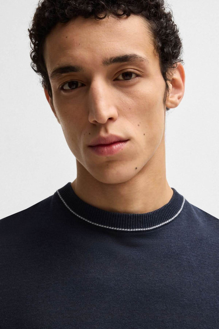 Homme portant un t-shirt en lin bleu marine avec col rond et finition contrastée.