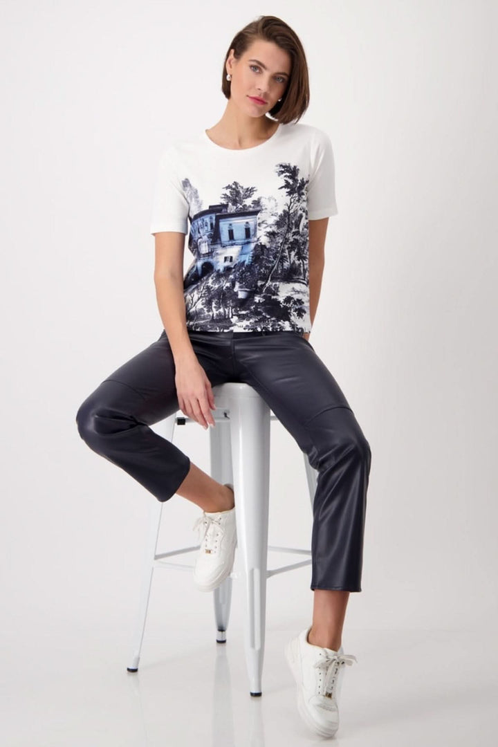 Model wearing Jardin Anglais printed t-shirt with jeans and sneakers, showcasing chic casual style.