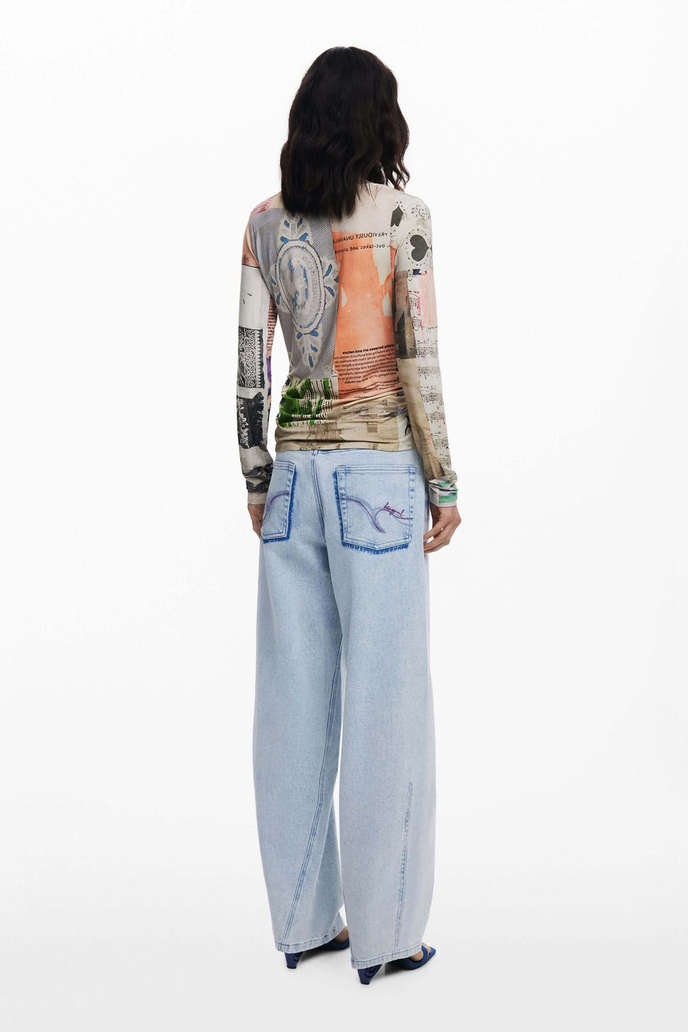 Dos d'un mannequin portant un T-shirt imprimé patchwork avec un jean ample, mettant en valeur l'imprimé artistique et les fronces latérales.