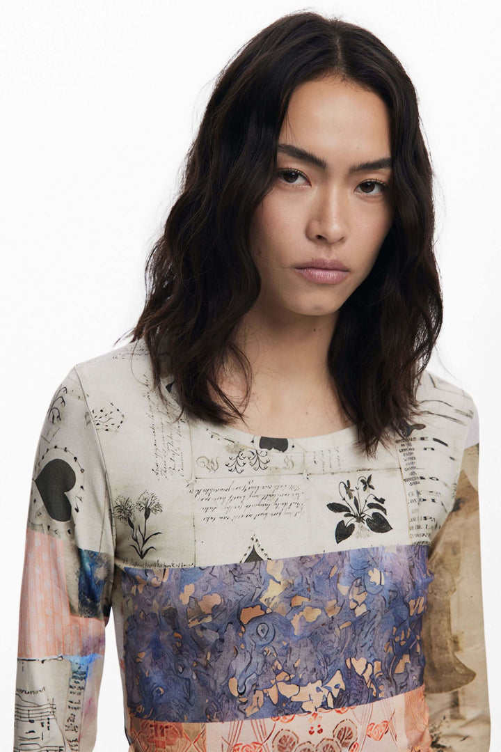 Femme portant un t-shirt imprimé patchwork avec imprimé artistique mêlant partitions et dessins botaniques.