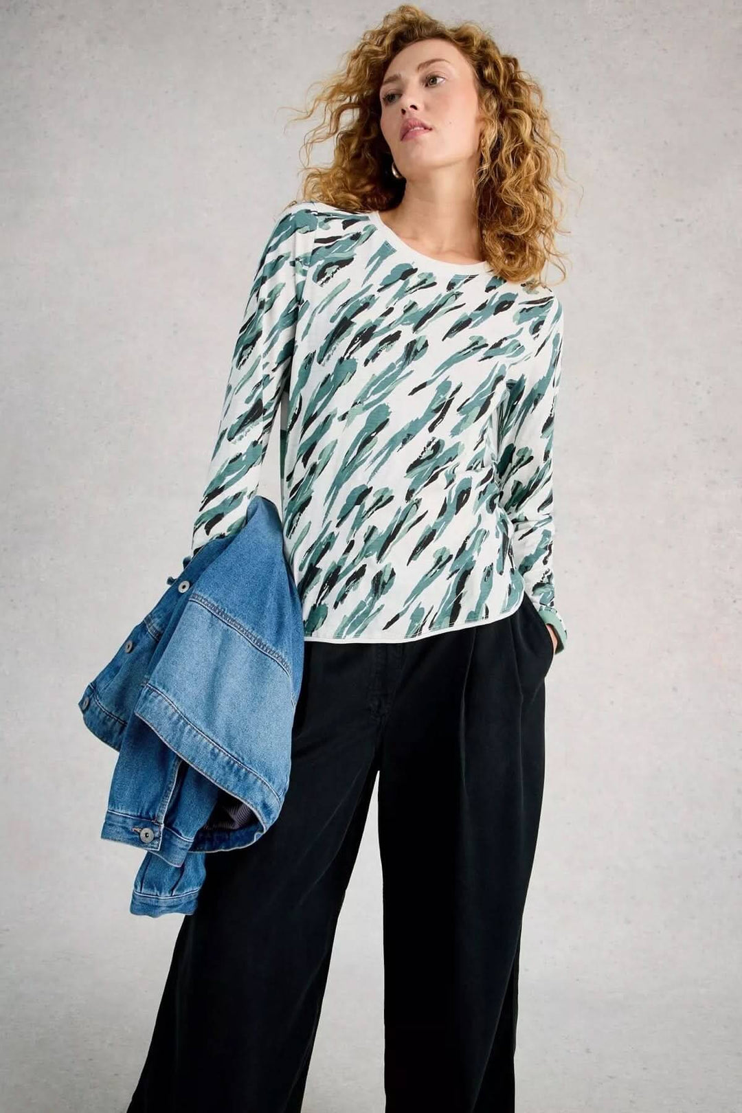 Femme portant T-shirt à manches longues Clara avec un motif, tenue décontractée.