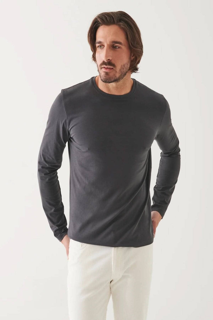 Homme portant un t-shirt à manches longues gris en coton Pima, col rond, devant un fond blanc.