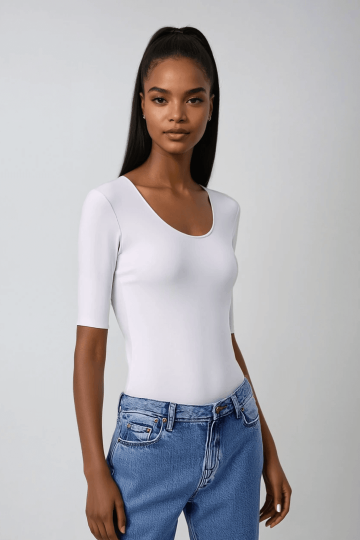 T-shirt blanc à manches mi-longues avec encolure dégagée, porté avec un jean, style élégant et confortable.