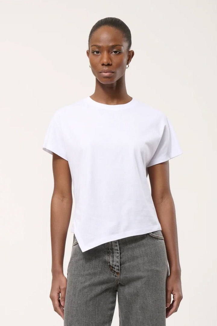 T-shirt à ourlet asymétrique blanc porté par une personne, coupe droite et fluide, confortable et moderne.