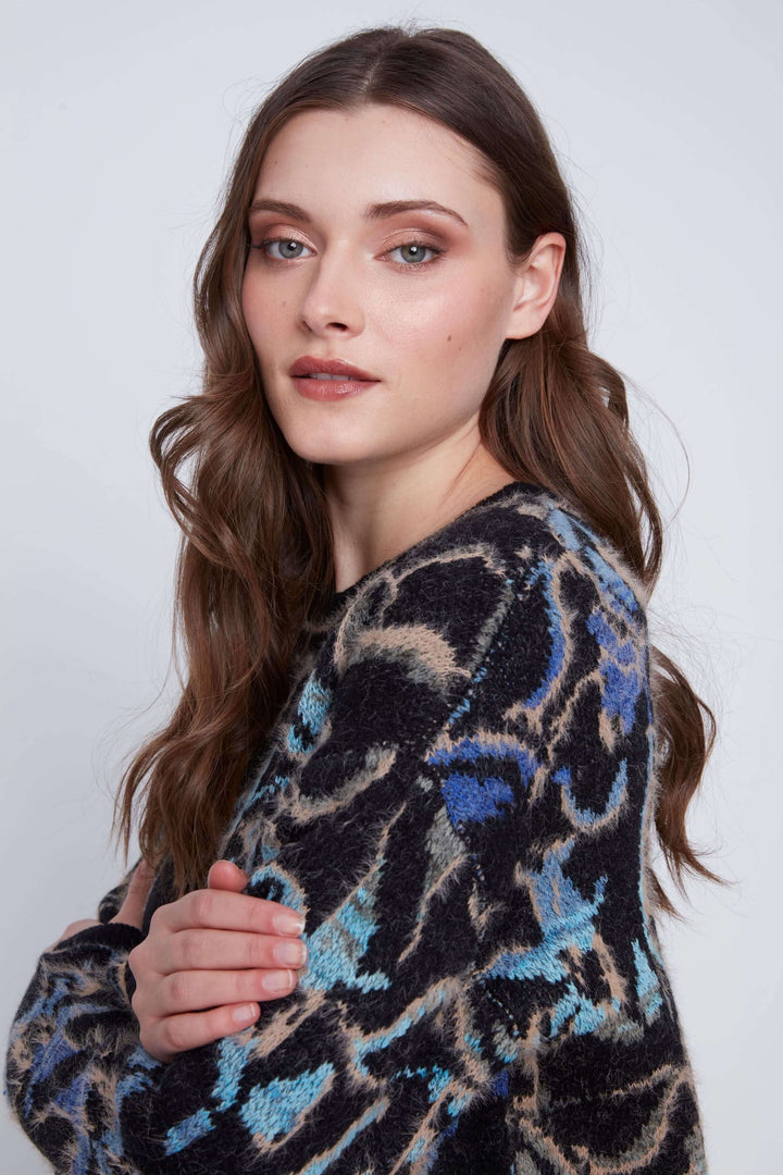 Tricot motif abstrait à manches longues avec motif artistique, porté par un modèle, mettant en valeur son design moderne et texturé.