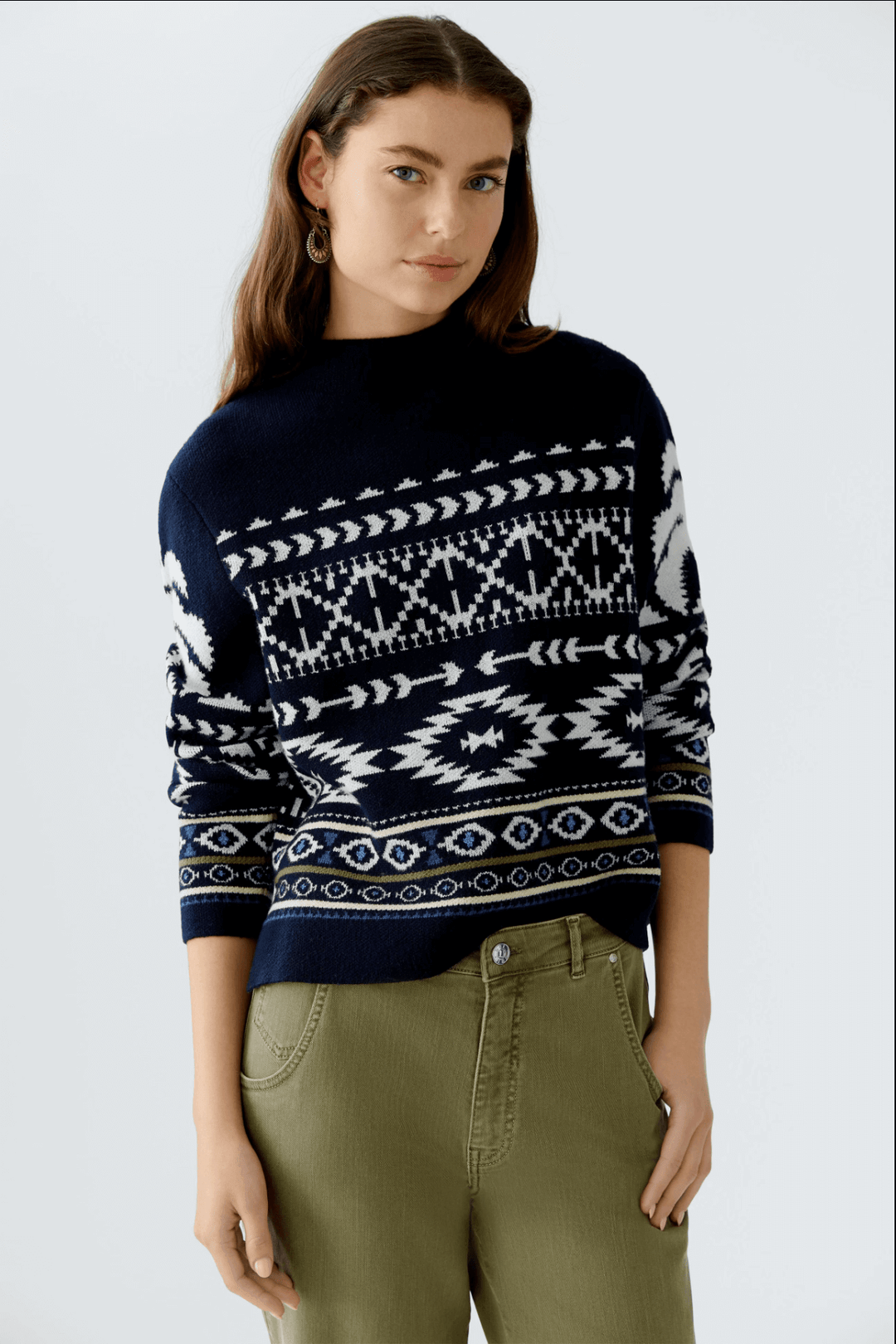 Tricot motif norvégien en jacquard avec col montant, manches longues et coupe décontractée, porté avec un pantalon vert.