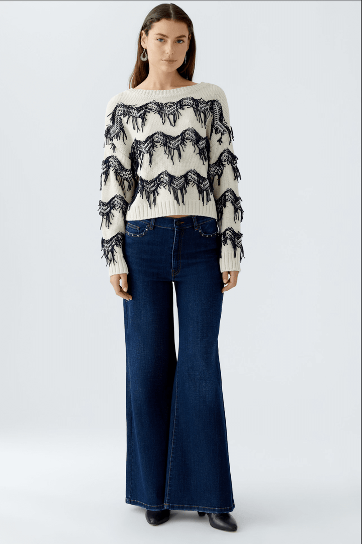Tricot motif zigzag avec franges, coupe carrée sur mannequin, encolure sous-marine et pantalon taille haute.