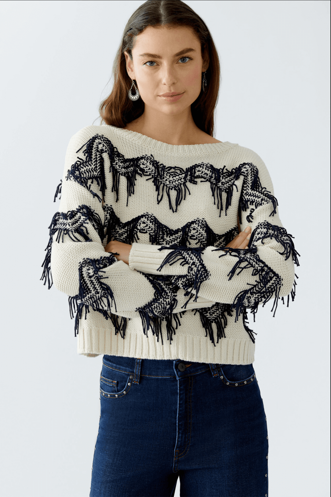 Tricot motif zigzag avec franges, coton, coupe carrée, encolure sous-marine, moderne et décontracté, porté avec pantalon taille haute.