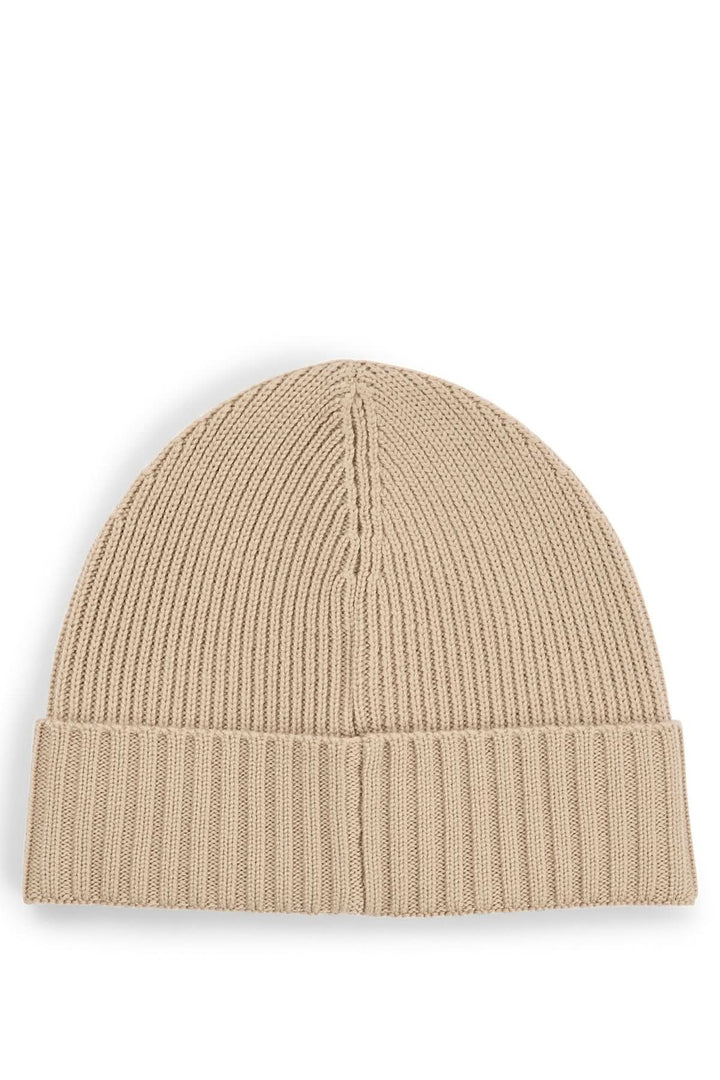Bonnet en laine beige, tricoté avec une structure côtelée, accessoire tendance et douillet.