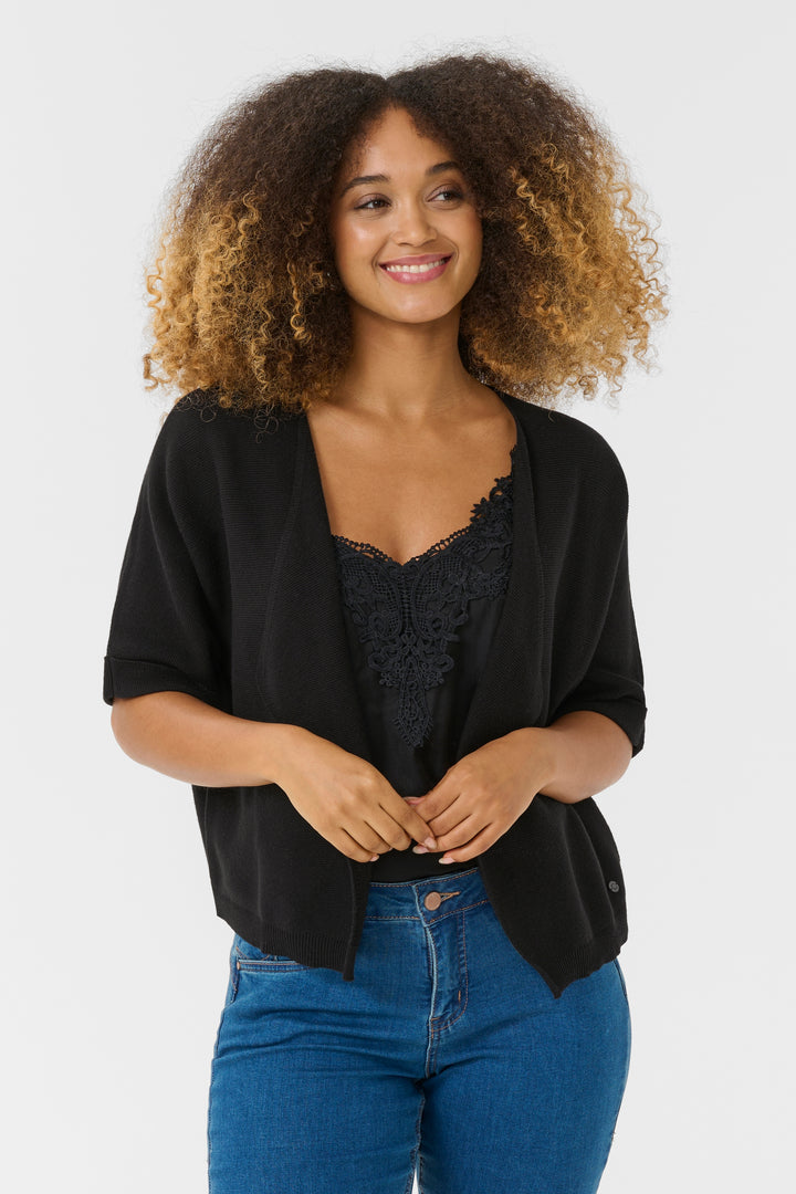 Femme portant une Veste avec manches Sillar noire, coupe fluide et ouverte, idéale pour superposer sur une camisole.
