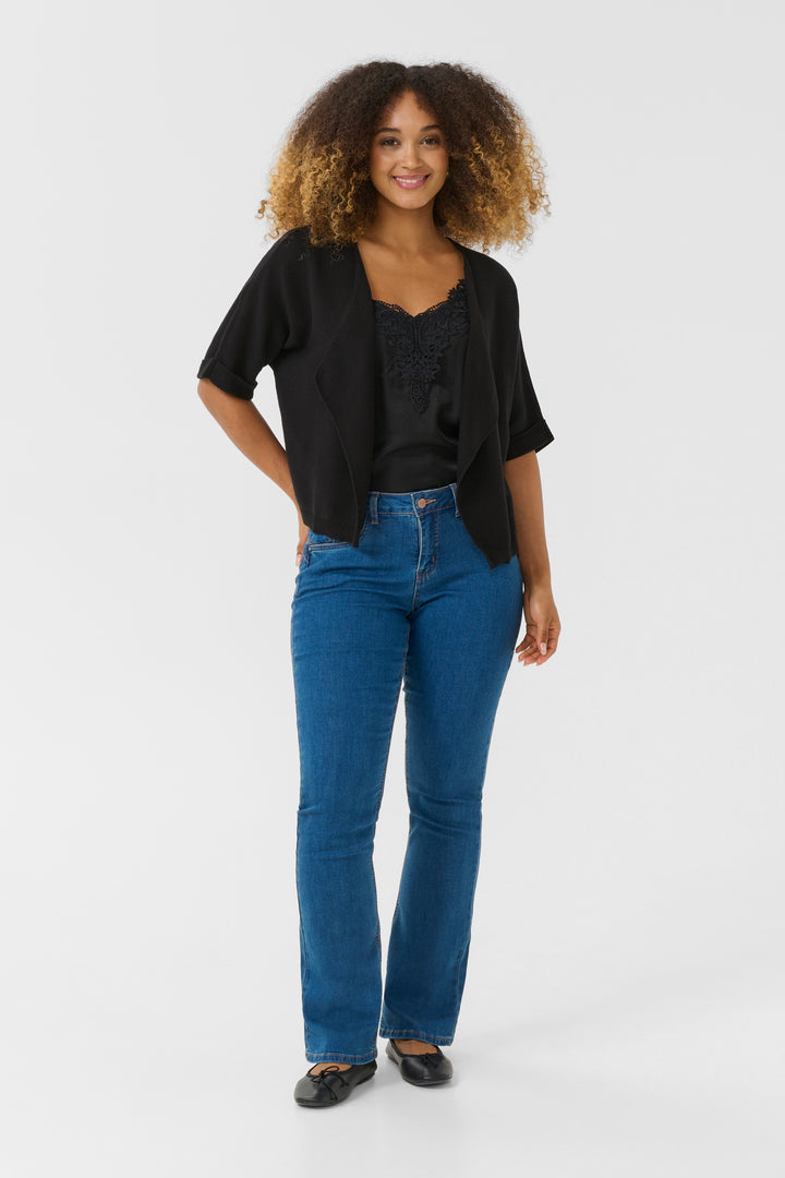 Femme portant la Veste avec manches Sillar noire, coupe fluide, ouverte, style moderne sur jeans et camisole, manches courtes.
