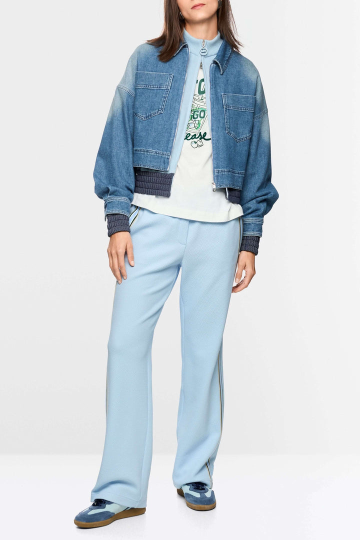 Veste courte en jean avec fermeture éclair portée par une femme, silhouette moderne et détails utilitaires, denim souple pour confort.