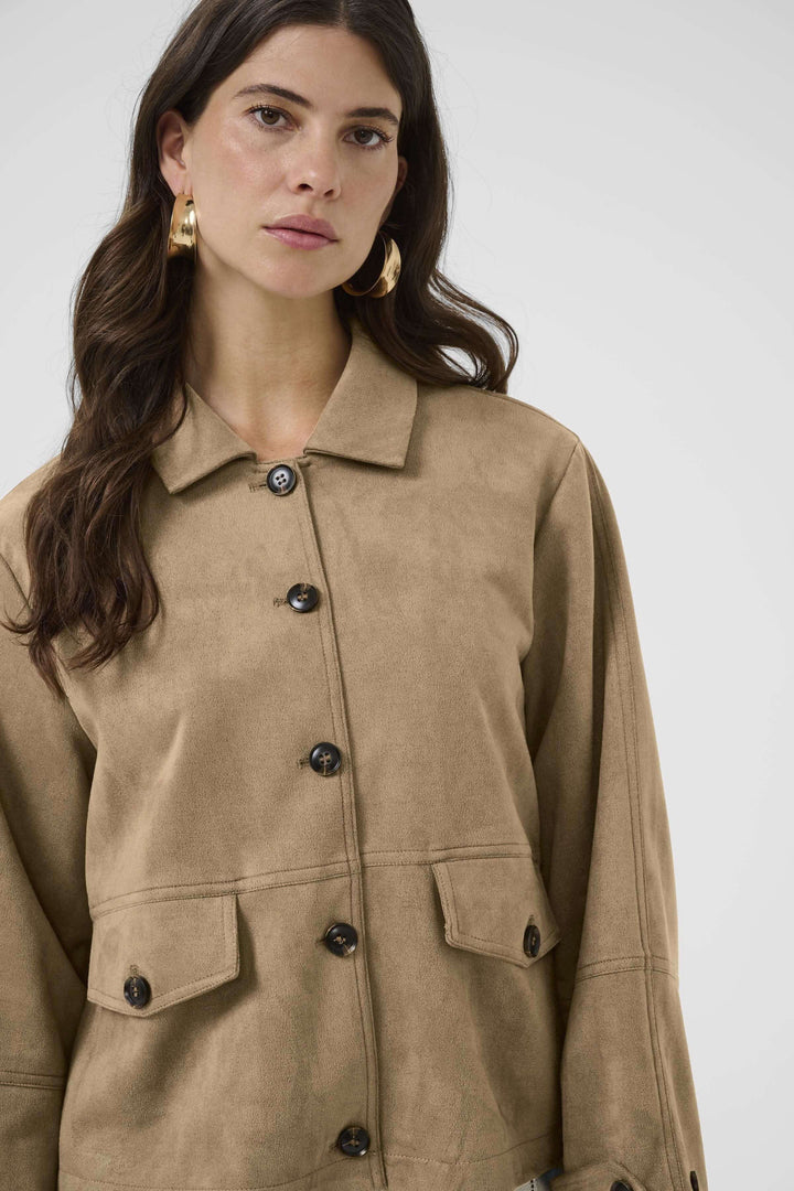 Femme portant une Veste décontractée Cala en matière effet suédé, chic utilitaire, coupe droite structurée pour mi-saison.